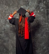 a woman wearing a graduation gown and a black hat